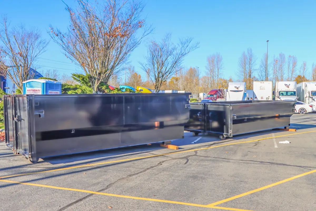 Professional dumpster rental service with roll-off container on residential driveway in West Earl